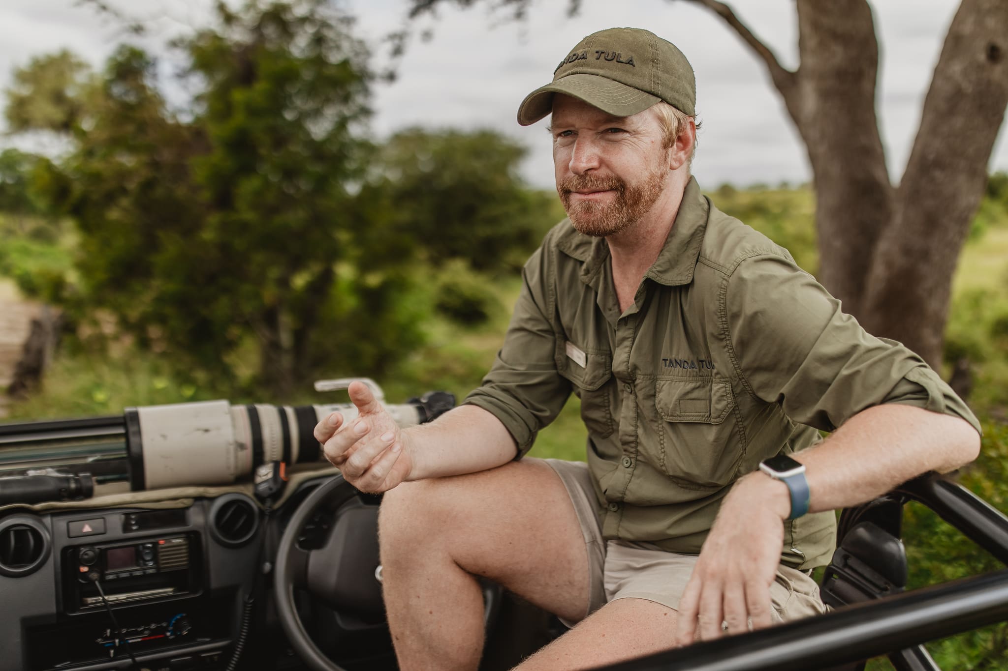 A Tanda Tula field guide sitting on a safari vehicle, speaking with guests in the Timbavati wilderness.
