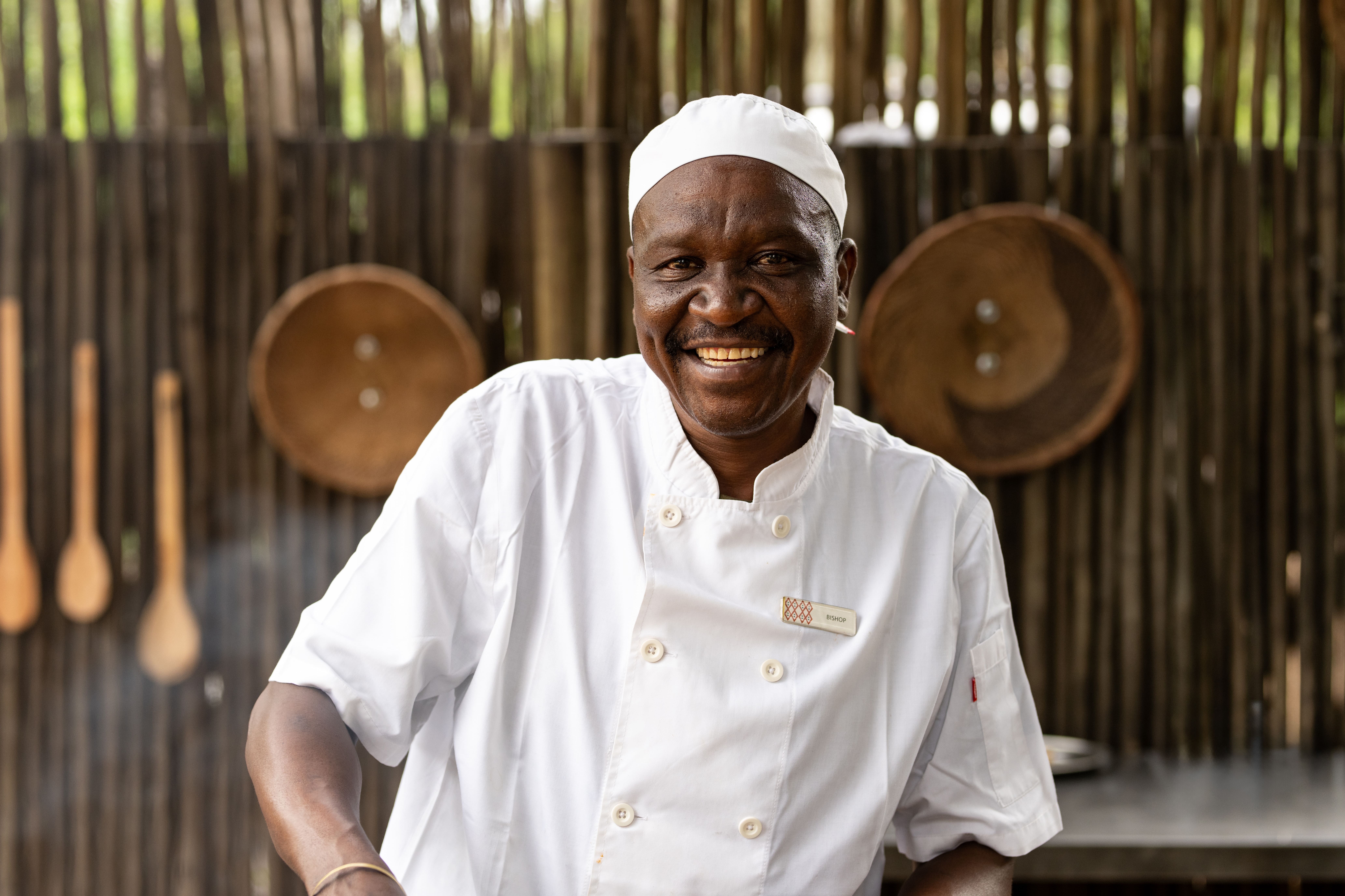 Tanda Tula chef smiling warmly in the open-air kitchen at the safari camp in the Timbavati.