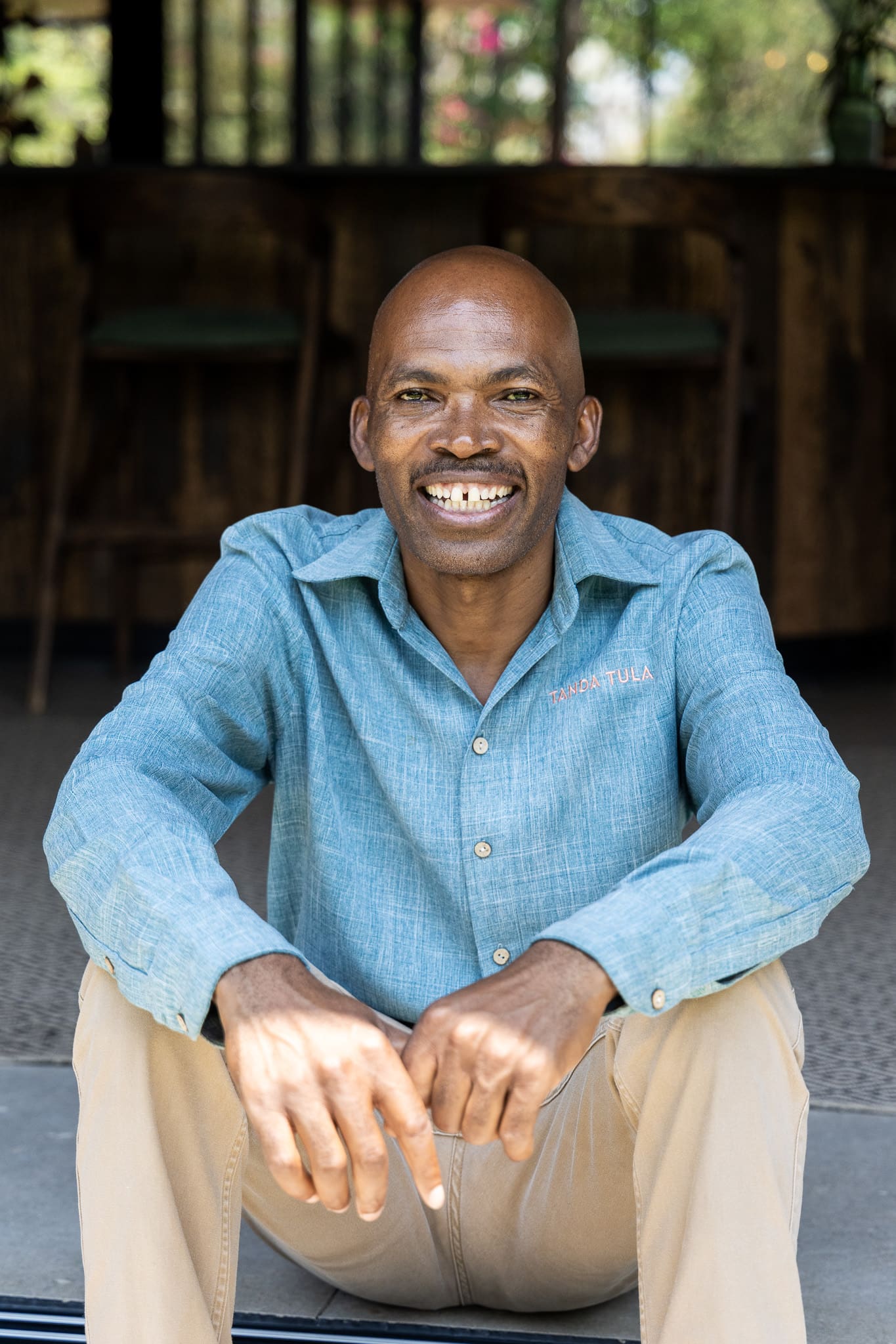 Formen Mathebula, co-owner and manager at Tanda Tula, smiling warmly outside the lodge.