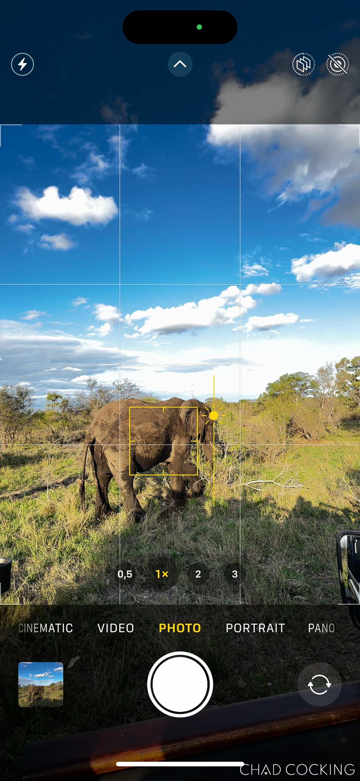 iPhone camera screen showing the exposure slider being moved upward to brighten the image.