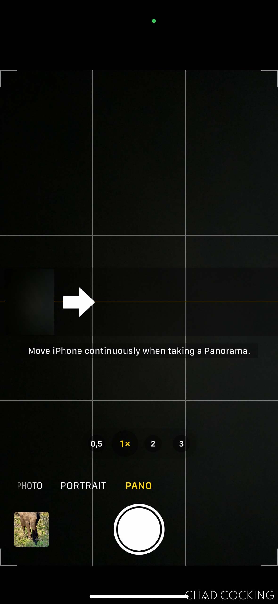 iPhone camera screen in Panorama mode with an arrow indicating which direction to move the phone.