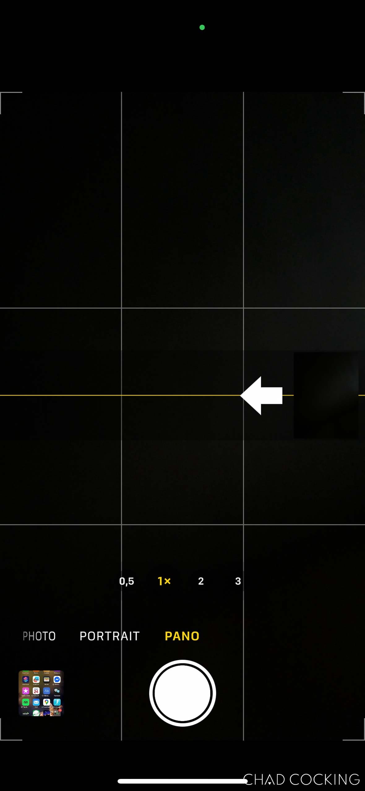 iPhone camera app in Panorama mode with the arrow pointing left to indicate a reversed sweep direction.