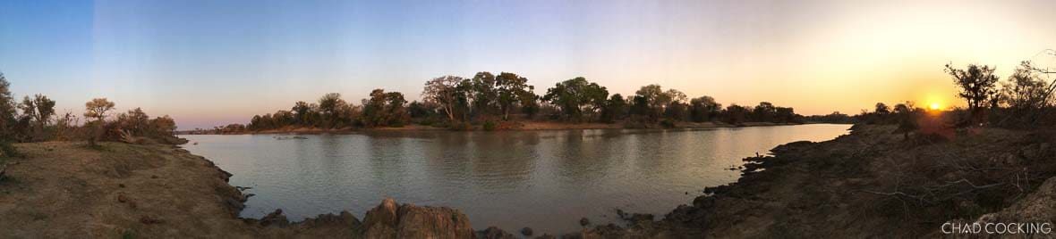Panoramic view of a river at sunset in the Timbavati, showing uneven lighting across the sky due to unlocked exposure.