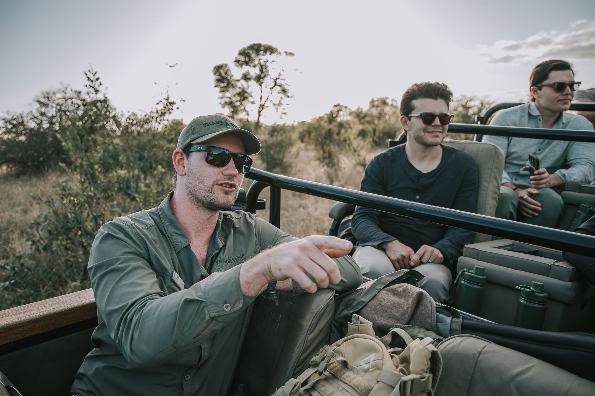 Field guide Tristan Allan-Reynolds pointing out wildlife to guests during a game drive at Tanda Tula.
