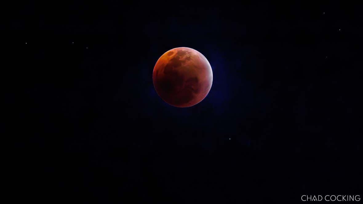 Blood-red lunar eclipse glowing against a clear night sky over the Timbavati.