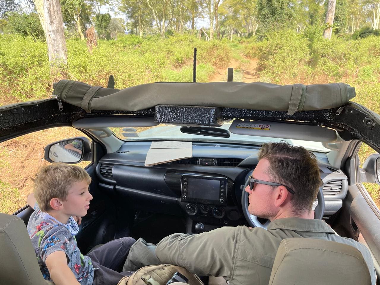 Field guide Tristan Allan-Reynolds listening attentively to a young guest during a safari drive in Pafuri.