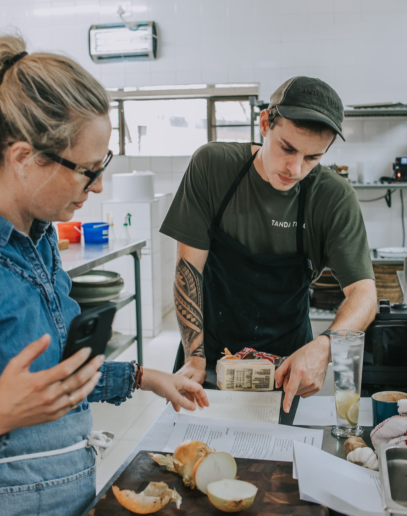 Tanda Tula kitchen team reviewing a recipe together while preparing ingredients in the safari camp kitchen